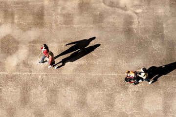 Wall Mural - top aerial view of people walking in work time at pedestrian plaza in autumn season. with lighting and shadow. Silhouette people concept