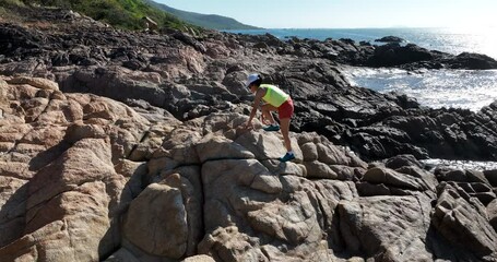 Canvas Print - Woman runner running on sunrise seaside rocks, slow motion