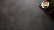 © Aris Suwanmalee - A cup of coffee on the rim of a black table.