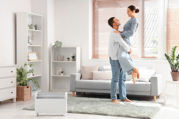 Poster - Happy young couple warming near radiator at home