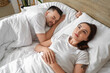 © Pixel-Shot - Awake young woman with her sleeping husband in bedroom