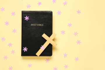 Wall Mural - Holy Bible with cross and decorative snowflakes on yellow background. Concept of Christmas story