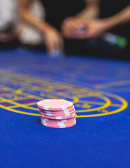 Wall Mural - Vibrant casino table with roulette in motion, with casino chips, tokens, the hand of croupier, dollar money and a group of gambling rich people playing bet, blue poker table and deck of cards