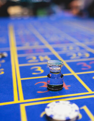 Wall Mural - Vibrant casino table with roulette in motion, with casino chips, tokens, the hand of croupier, dollar money and a group of gambling rich people playing bet, blue poker table and deck of cards