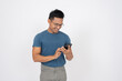 © bongkarn - A positive Asian man in casual clothes is using his smartphone, isolated white background. chatting