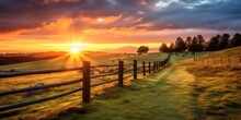 Landscape Featuring A Fenced Ranch At Sunrise With Sunlights Shimmering And Creating A Defocused Effect