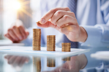 Wall Mural - Businessman stacking coins on table, business growth concept. Hand puts coin to stack.