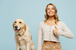 Young smiling happy owner woman with her best friend retriever dog wears casual clothes show thumb up like gesture isolated on plain pastel light blue background studio. Take care about pet concept.