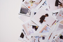 Scattered Polaroids Of Creative Process. Chaotic Yet Creative Spread Of Polaroid Photos Capturing A Man In Motion, Actively Engaging With His Work In An Office Space Filled With Design Plans 