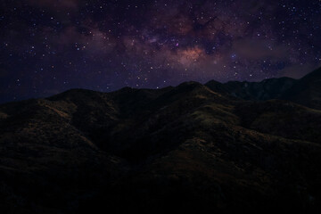 Wall Mural - Landscape with Milky Way. Night sky with stars on the mountain,