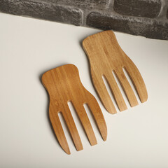 Wall Mural - Wooden salad hands, bamboo kitchen utensils, bamboo salad hands, wooden salad spoons, close-up and concept shot. e-commerce photos, free space for writing,