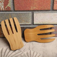 Wall Mural - Wooden salad hands, bamboo kitchen utensils, bamboo salad hands, wooden salad spoons, close-up and concept shot. e-commerce photos, free space for writing,