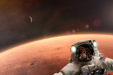 Wall Mural - the astronaut takes a selfie against the backdrop of the planet mars. elements of this image courtes