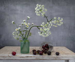 Wall Mural - A small bouquet of wildflowers and ripe cherries.