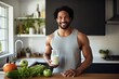 Muscular happy african american guy with glass of milk cooks a healthy meal in his kitchen, promoting a fit and balanced lifestyle.