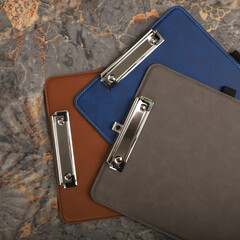 Colorful leather clipboard. Genuine leather clipboard, concept shot, top view, different color, clamshell and stitched clipboard