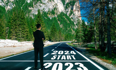 Wall Mural - 2024 New Year journey and future vision concept . Businessman traveling on highway road leading forward to happy new year celebration in beginning of 2024 for bliss and successful start .