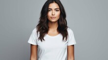 Waist Up Shot Of Pleasant Looking Woman With Piercing In Nose Dressed In Casual T Shirt Keeps Arms Down Being In Good Mood Isolated Over White Background. People And Positive Emotions