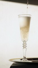 Wall Mural - Champagne pouring into a glass, isolated on the white background