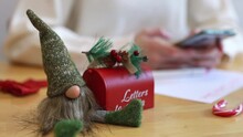 Toy Gnome With A Mailbox For Letters From Santa Claus On The Table.