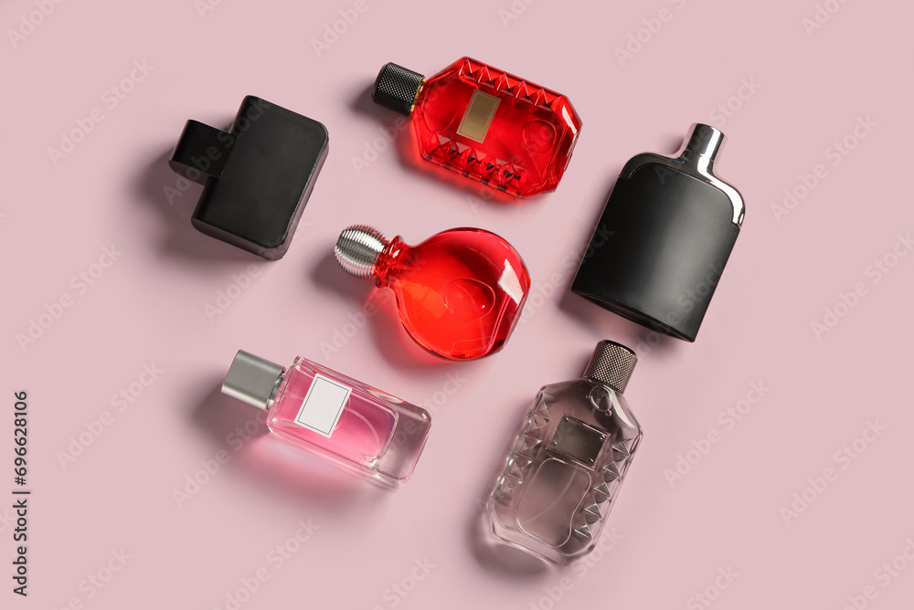 Bottles of luxury perfume on pink background