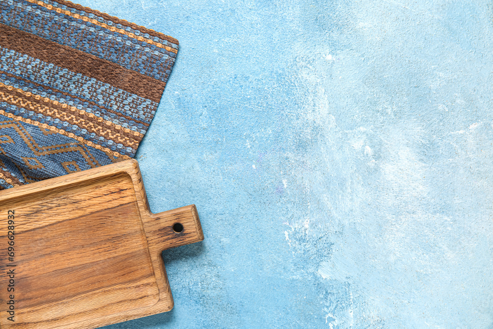Wooden board with napkin on grunge blue kitchen table