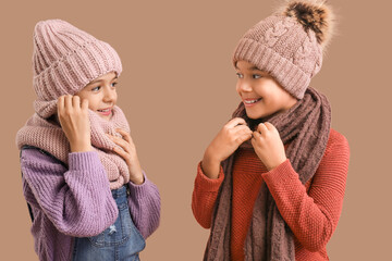 Poster - Cute children in winter clothes on beige background