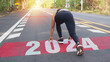 © sutlafk - Woman begin to run on the road, start of New year 2024, planning, goal, and new year.