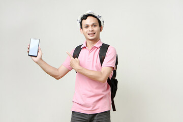 Asian man backpacker showing cellphone blank screen with empty space for mobile app on screen. travelling concept. on isolated background