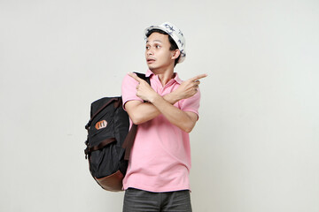 Asian man backpacker with confused expression. travelling concept. on isolated background