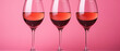 Three Wine Glasses Filled with red  Wine on a Pink Background