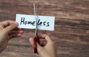 Scissors cutting word homeless on paper