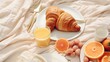 A delicious assortment of fresh fruit and warm croissants arranged on a plate, placed on a bed. Perfect for breakfast in bed or a hotel room service concept