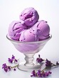 Bowl of violet ice cream balls on white background.