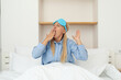© Atlas - A young girl yawns in bed with a sleeping mask