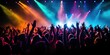 © piai - Crowd on a concert with hands raised, colorful light beams