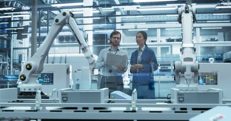 Fototapete - Young Engineer and Asian Technician Having a Conversation and Using a Laptop Computer. Specialists Monitoring, Analyzing Conditions at a Modern Electronics Factory with Automated Assembly Line