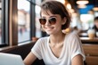 © drimerz - woman in sunglasses with laptop in cafe