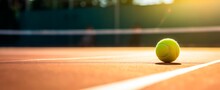 Tennis Ball On Tennis Clay Court With Soft Focus At Sunset  Tennis Tournament Concept Horizontal Wallpaper Background, Copy Space For Text 