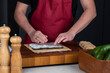 Close up of sushi chef hands preparing Japanese food. Man cooking sushi at restaurant or at home. Portion of Traditional Asian rice on nori seaweed.
