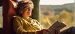 © Postproduction - Mature woman enjoying a scenic train journey, reading a book and sipping hot tea. Relaxing travel experience