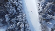 Woman walking in the snow view by drone
