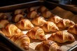 © FoxTok - Fresh crispy golden croissants lie on a baking sheet close-up. Sweet pastry made from puff pastry, a classic French dessert. Bakery concept, croissant production
