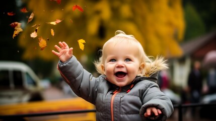 Baby child playing with fallen leaves, autumn season beautiful scene, laughing blond toddler happy, smiling in the wind, outdoors scenery with the colors of fall, day in the country, nature and trees