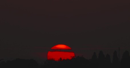 Wall Mural - Big Sunrise Timelapse video Close-up the sun in red cloud sky over horizontal.ProRes422