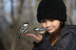 young child feeding birds in forest