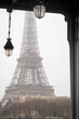 The Eiffel Tower through the Bir Hakeim bridge in the rain in Paris