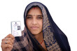 Indian rural woman wearing a sari with smiling face shows her blurred voter card in her hand, isolated white background