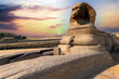 Egyptian Great Sphinx full body portrait with head, feet with all pyramids of Menkaure, Khafre, Khufu in background on a clear, blue sky day in Giza, Egypt empty with nobody. copy space
