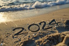 Hand Writting Of 2024 On Sand Beach Happy New Year Concept Background.